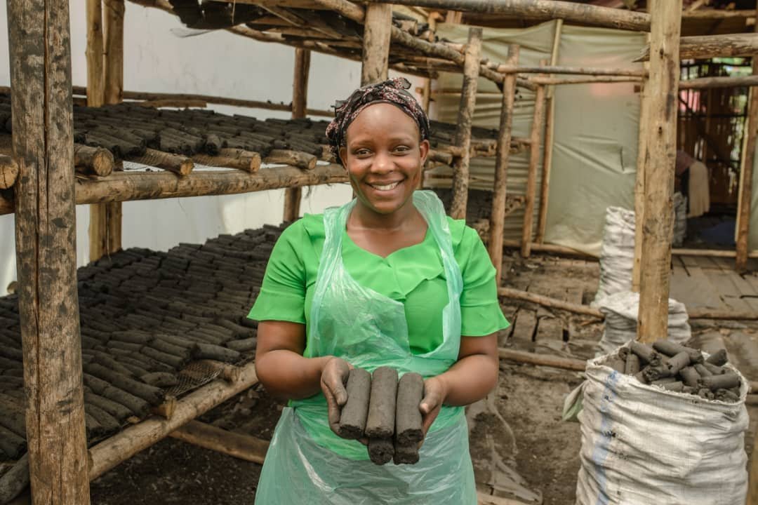 Gracela Ventures team presenting locally produced biomass briquettes